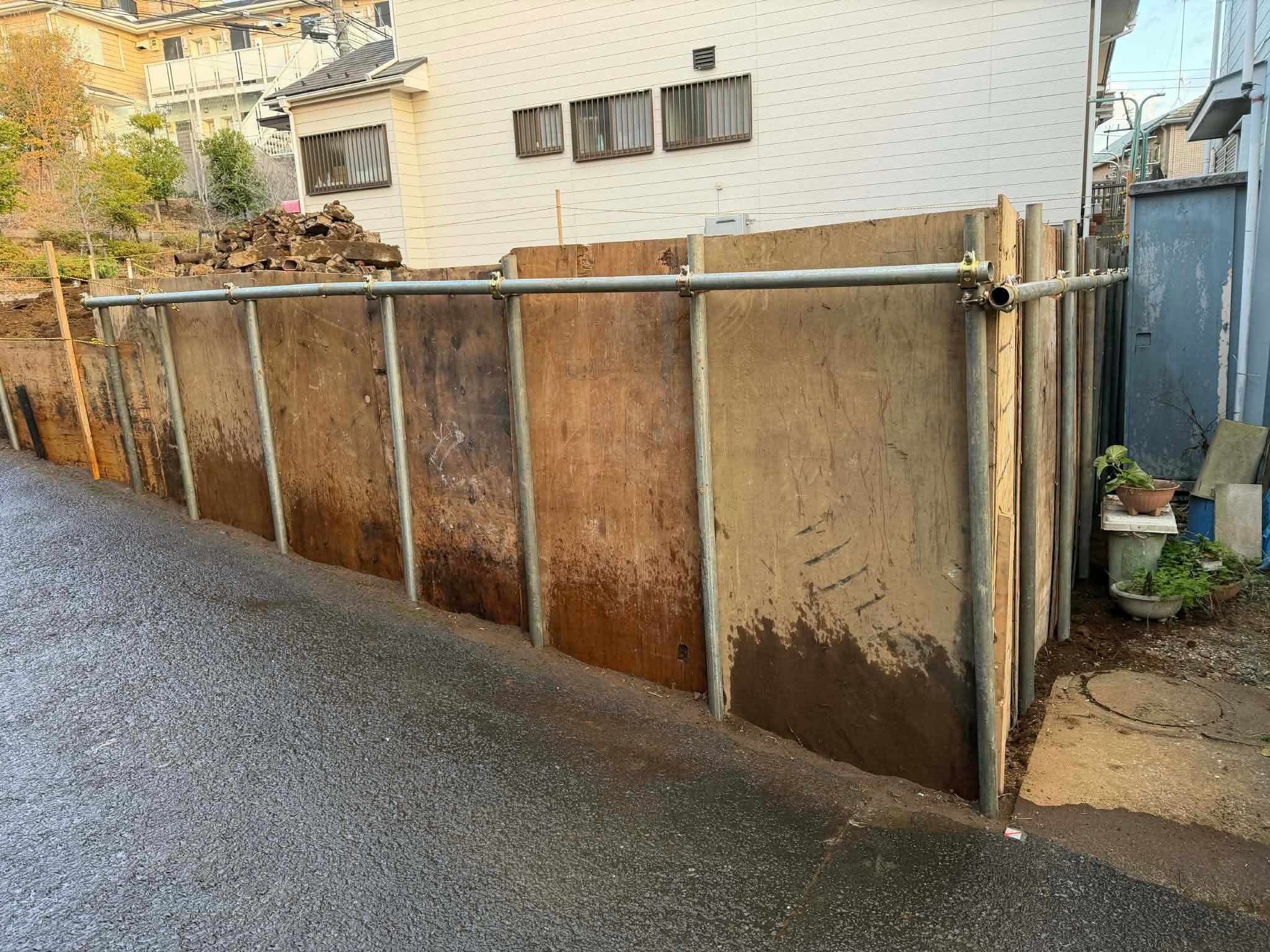 2025/12/09の解体状況：ブロック擁壁撤去→仮設土留め（単管＋合板）、境界隣家との調整が最大の課題